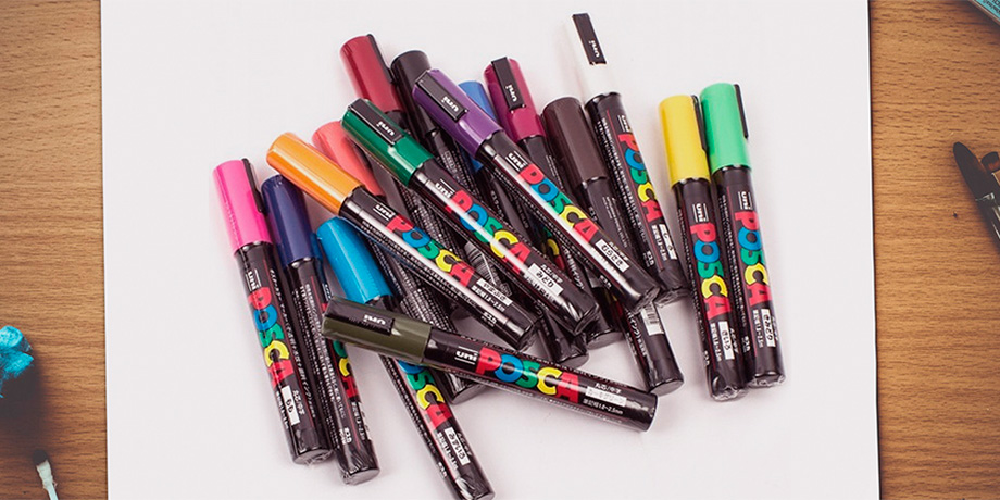 canetas-posca-de-varias-cores-sobre-papel-em-branco