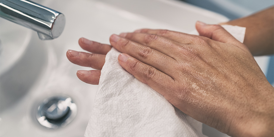 homem secando as mãos com papel toalha
